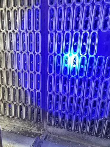 Technicien réalisant la détection de fuite sur un équipement industriel à l’aide d’une lampe UV.