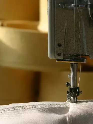 Couture d'une manche en tissu de verre membrané dans un atelier de production de TTL France.