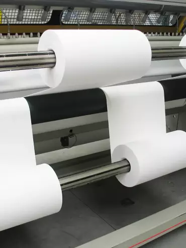 Machine à découpe Calemard utilisée pour la découpe des rouleaux textiles industriels.