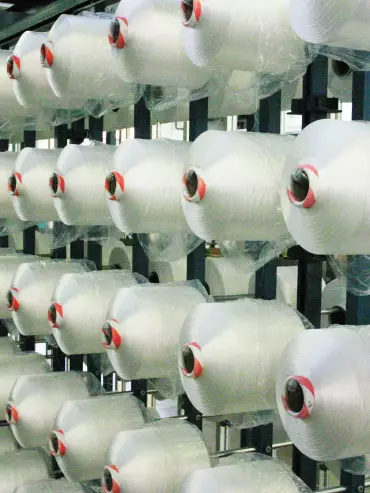 Machines en fonctionnement pour la filature et le filage de fibres textiles dans un atelier Testori.