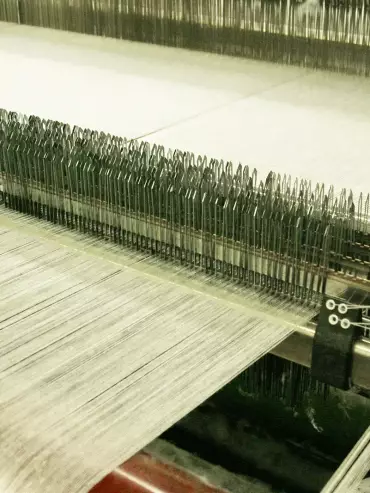 Métier à tisser en fonctionnement pour la fabrication des tissus techniques industriels.
