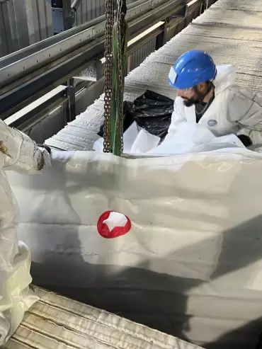 Technicien effectuant le montage d’une toile filtrante à l’intérieur d’un filtre-presse industriel.