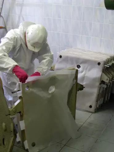 Opérateur procédant au remplacement d’une toile et d’un plateau sur un filtre-presse industriel.