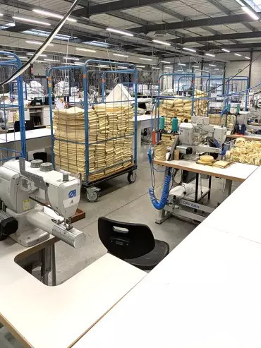 Atelier de confection des manches filtrantes chez TTL France, montrant le matériel de production.